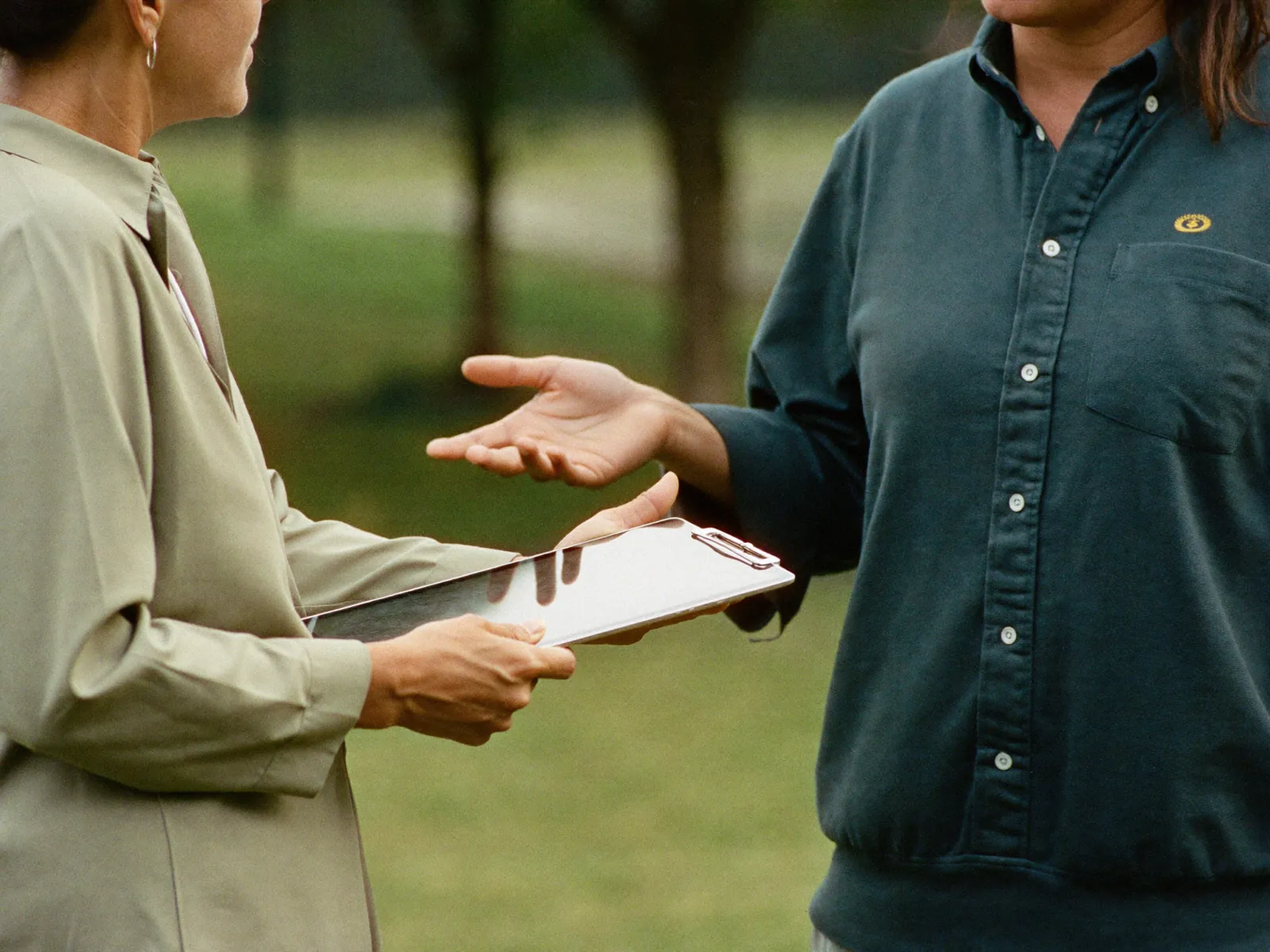 A field researcher collecting survey responses on a tablet outdoors