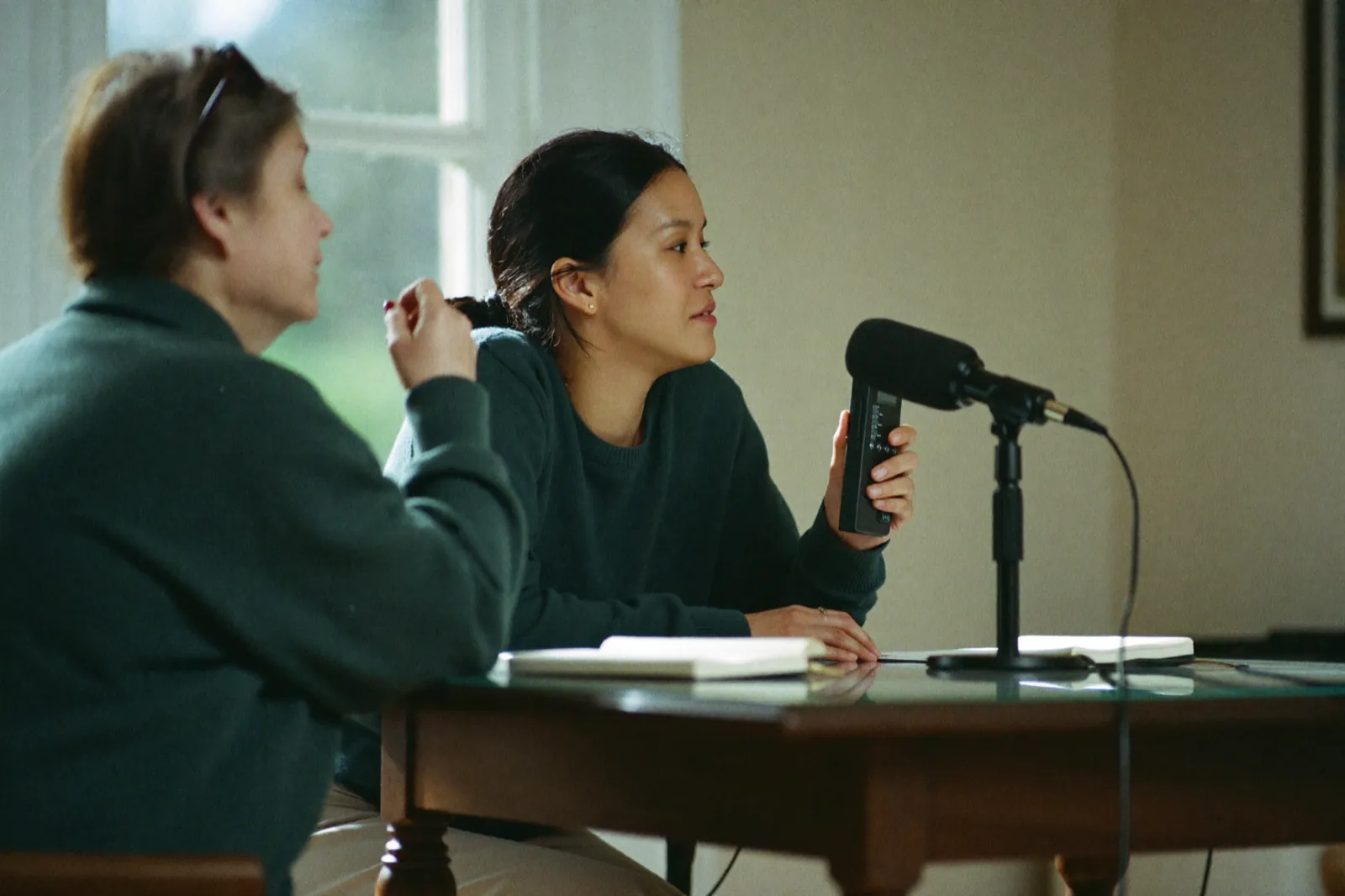 A researcher conducting a one-to-one qualitative interview, recorder on the table